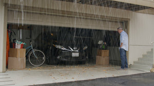Våd garage med en mand stående udenfor